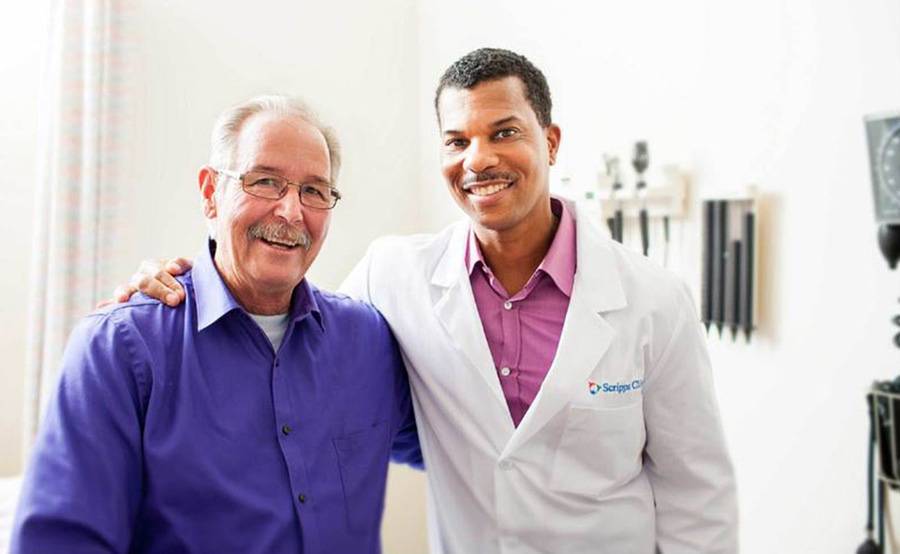 Scripps bariatric surgeon William Fuller, MD, stands with a patient after a follow up visit, illustrating the support services available after weight loss surgery.
