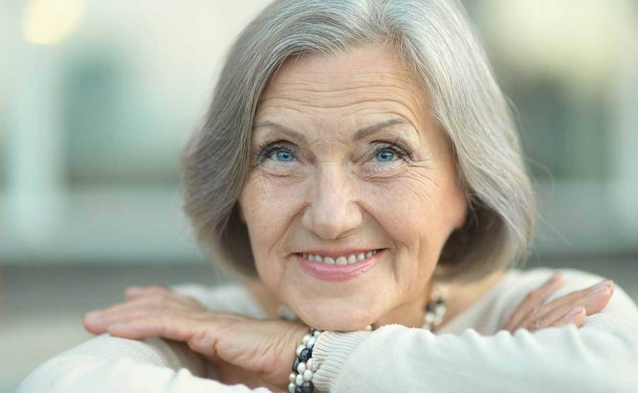 A smiling mature woman represents the full life that can be led after bile duct cancer treatment.