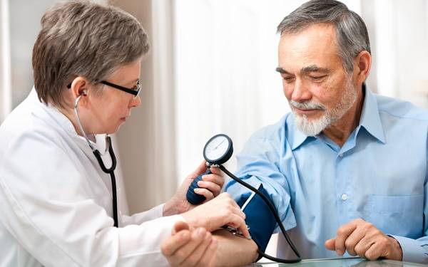 A Scripps doctor checks a patient's blood pressure.