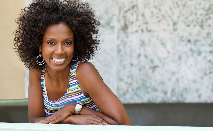 A smiling young African-American woman represents the full life that can be led after cervical cancer treatment.