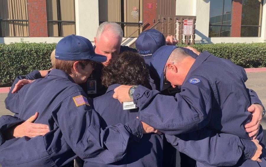 Scripps Medical Response Team huddles with heads bowed, before deploying to Northern California in 2018.