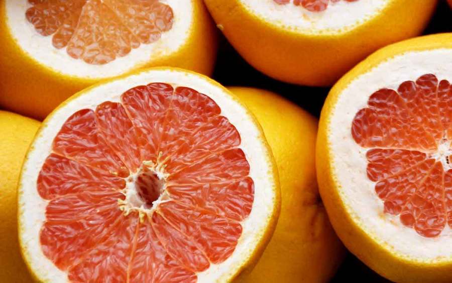 Pink and orange grapefruit and citrus fruits represent the types of superfoods you can plant in your garden.