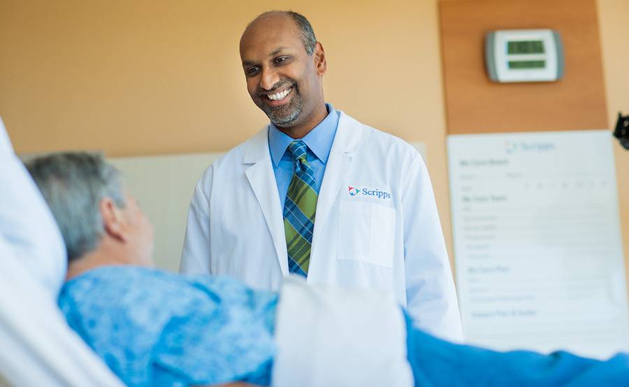 Dr. Sunil Rayan, a Scripps vascular surgeon, smiles during a conversation with a patient, representing care at Scripps for congenital heart defects.