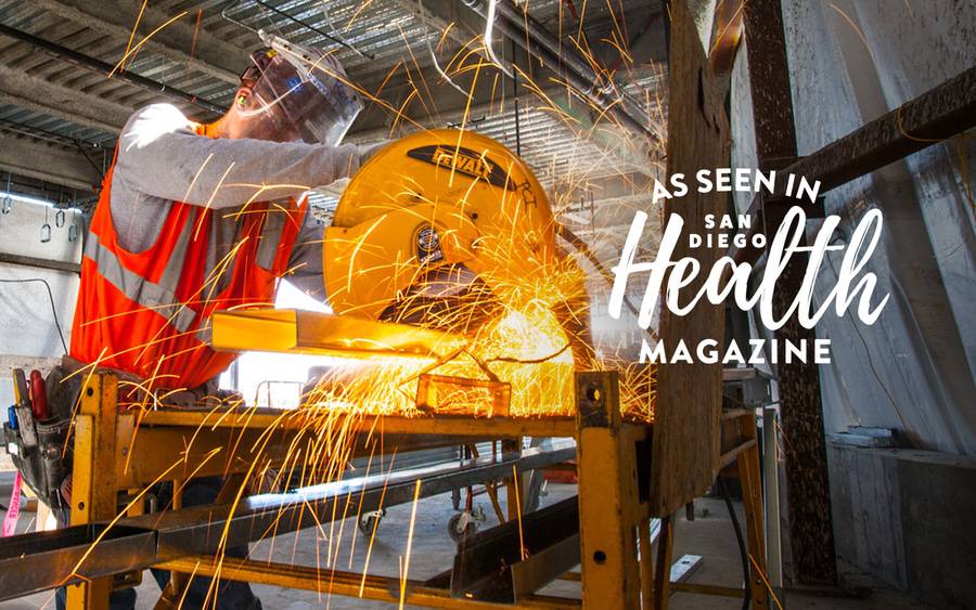 A construction worker uses a saw to cut a piece of steel - SD Health Magazine