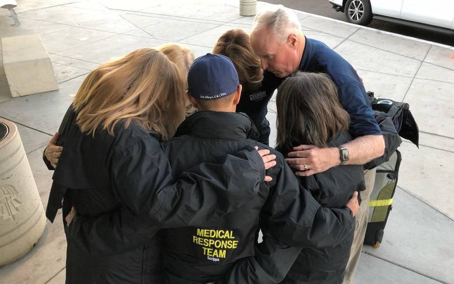 At San Diego airport, Chris Van Gorder, Scripps Health's president and CEO, huddles with members of Scripps nurses heading to Northern California to help fire victims.