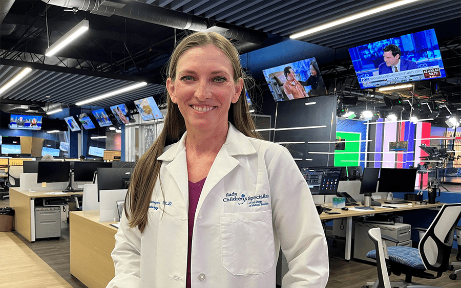 Dr. Casey Cohenmeyer, Rady Children's Hospital in the room where there are many televisions behind her.
