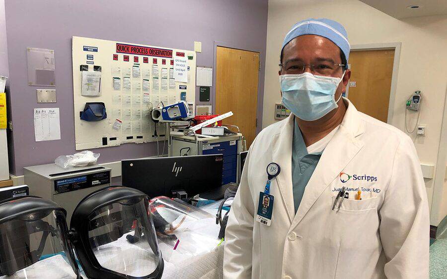 Dr. Juan Tovar stands next to face shields for coronovirus at Scripps. 