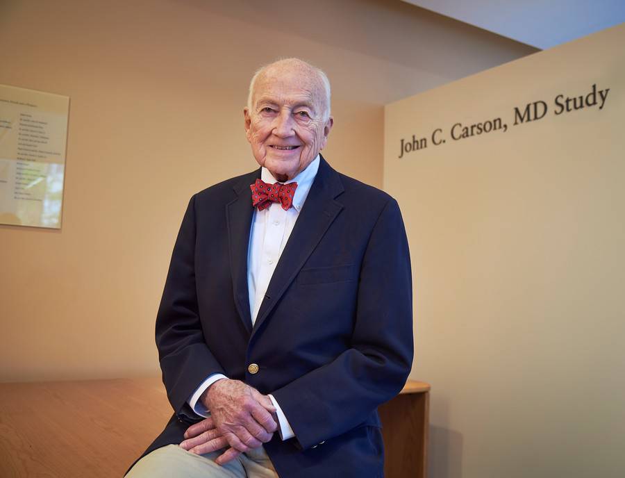 John Carson, a legendary Scripps cardiologist, smiles for a photo by the Scripps campus study that was named in his honor. 