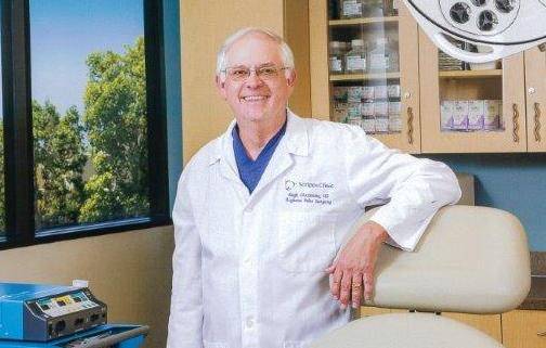 Hubert Greenway, MD, stands in a doctor's office after receiving a major skin cancer award.