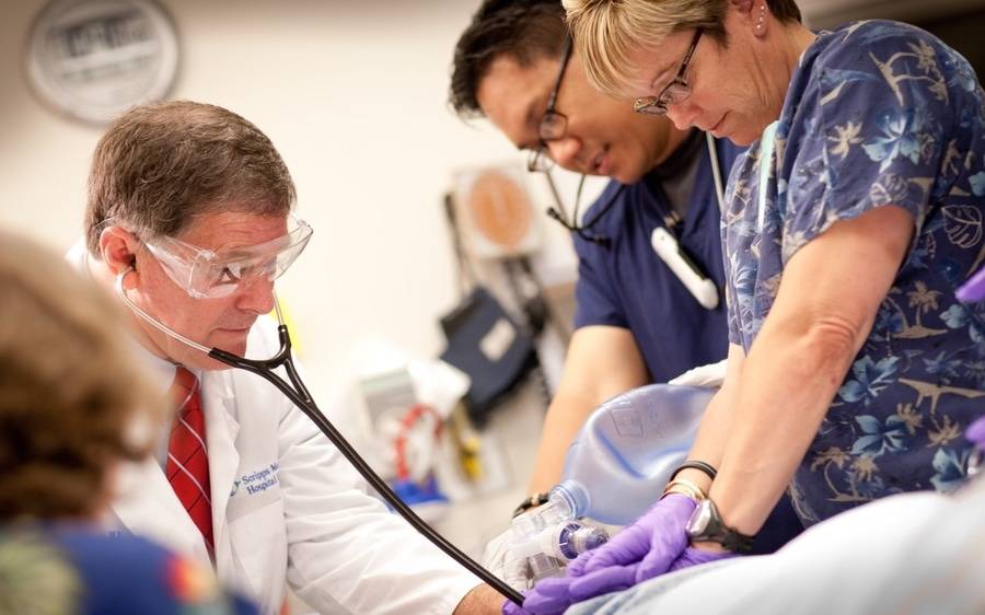 A Scripps doctor checks vitals on a patient in critical condition while a nursing staff provides CPR support.