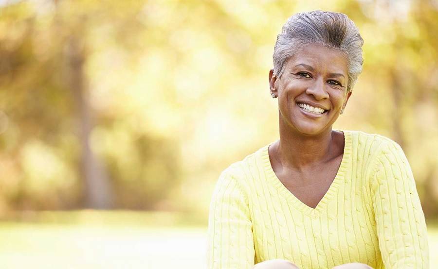 A smiling African-American woman represents the full life that can be led after gastrointestinal carcinoid tumor treatment.