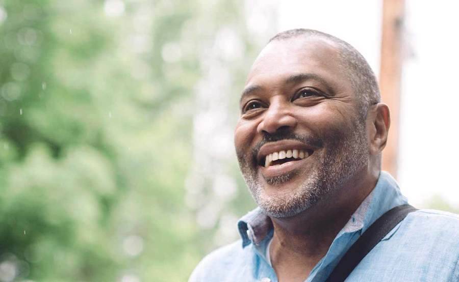 A smiling middle-aged African-American man represents the full life that can be led after treatment for genitourinary cancer.