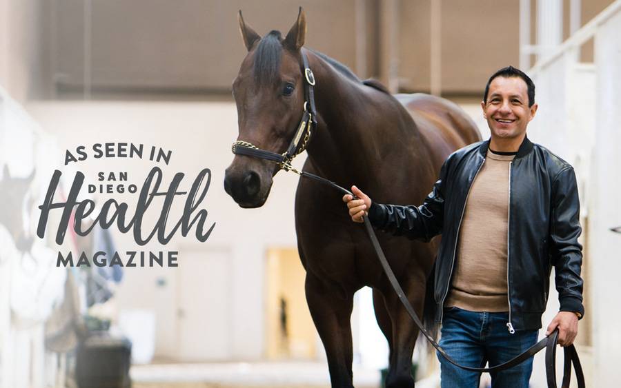 Hall of Fame jockey Victor Espinoza stands next to a racehorse, grateful to be back on his feet after Scripps Health treated his severe spinal cord injury.