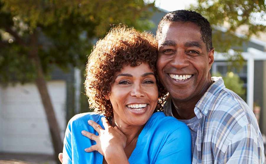 A smiling middle-aged African-American couple represents the full life that can be led after treatment for head and neck cancer.