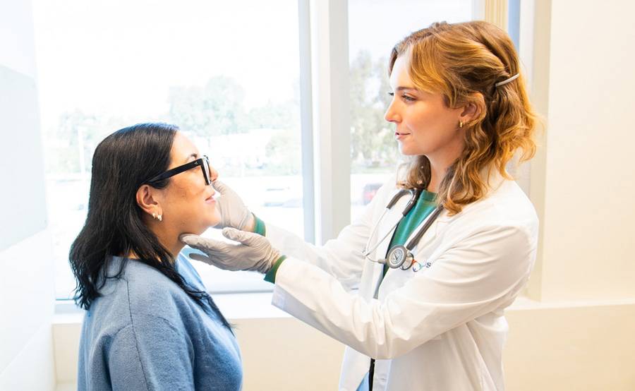A Scripps provider examines a patient standing up.
