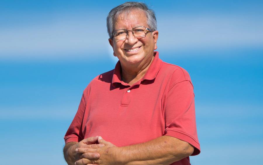 Volunteer and diabetes patient Hector Nunez smiles against a blue sky.