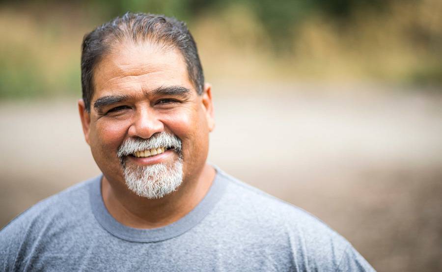 A man smiling outdoors, representing the active lifestyle that people often enjoy after bariatric surgery.