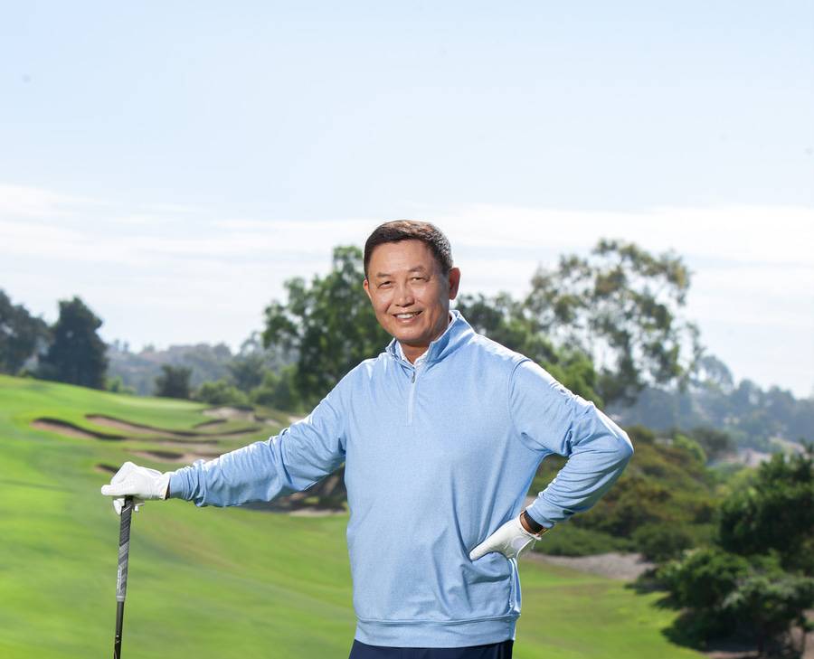 Jing Wang smiles on the golf course after successful retina surgery at Scripps.