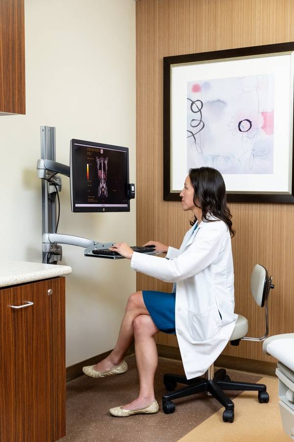 Jo Marie Tran Janco, MD, director of the gynecologic cancer program at Scripps Cancer Center, and gynecologic oncologist at Scripps Clinic, checks a patient's X-ray on the computer.