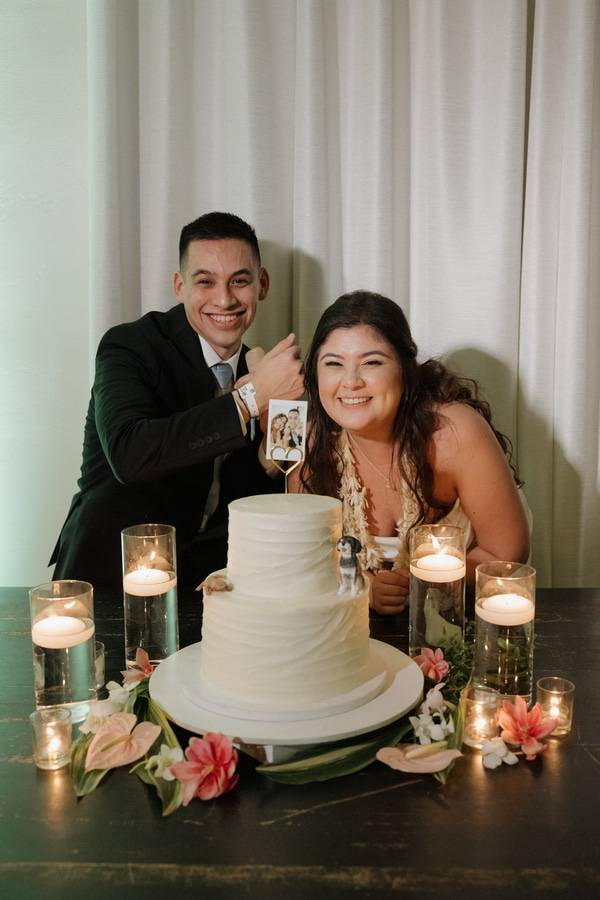 Jordan Mendoza and wife on their wedding day pictured with their cake.