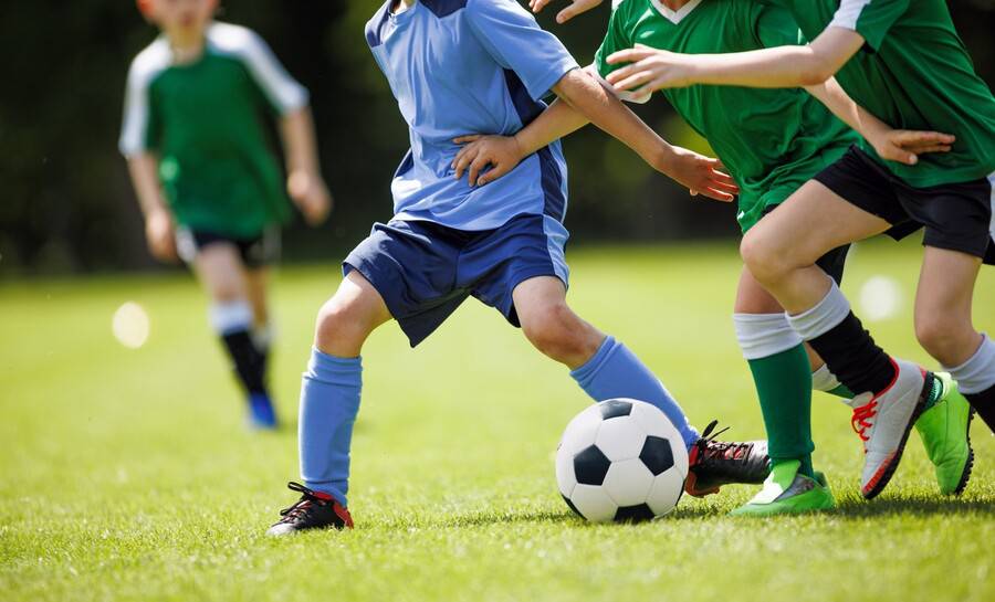 Kids playing soccer after being cleared to play with sports physical exam.