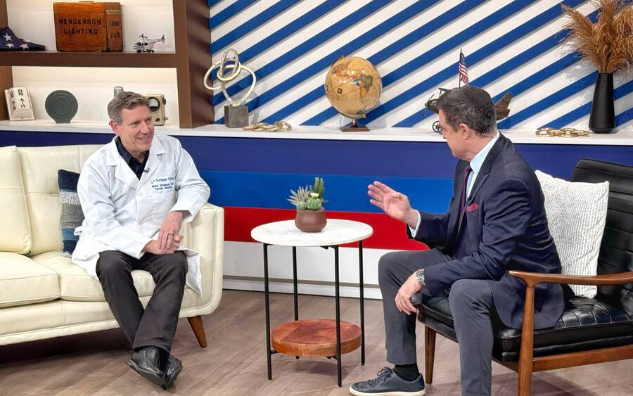 Mark Shalauta, MD, a Family Medicine doctor sitting on a couch and speaking to a KUSI anchorman.