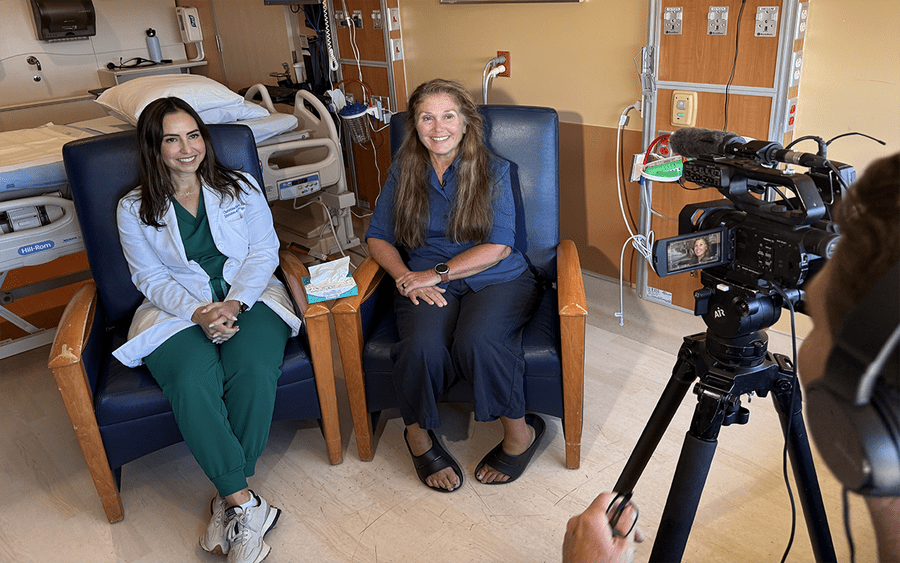 Both Christina Morcos and Kim Stevens are sitting in a patient room for a  tv interview.