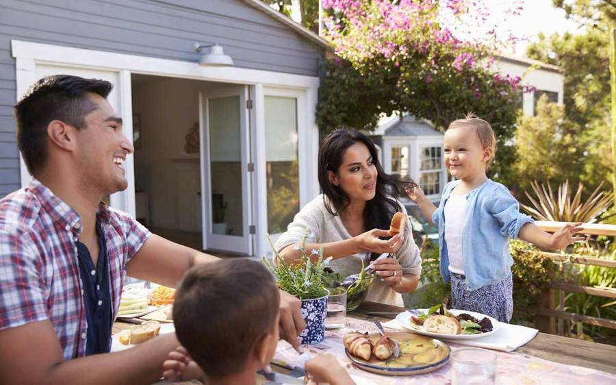 A young family enjoy a healthy meal in their yard, comprising fall food advice offered by a Scripps diabetes expert.