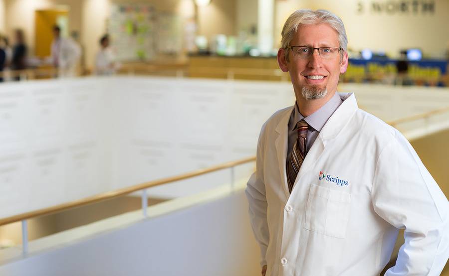 Jonathan Fisher, MD, stands in a bright, modern atrium, representing advanced pancreas transplant care at Scripps.