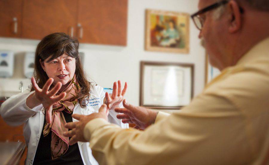 Scripps neurologist Dr. Melissa Houser assesses a man for hand tremors related to Parkinson's disease, representing the expert, compassionate care received at Scripps.