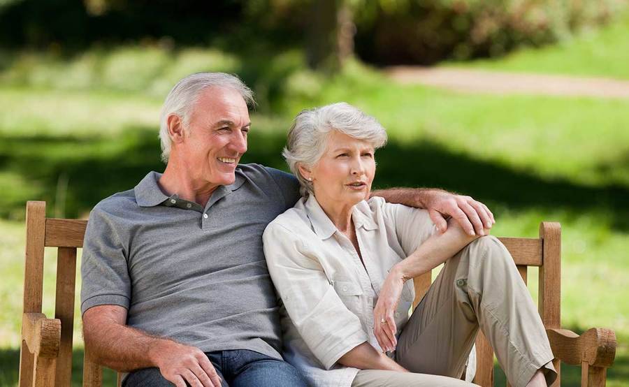 A mature couple on a park bench represent the full life that can be led after pituitary cancer treatment.