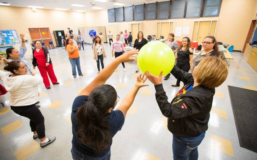 Members of the Scripps Prediabetes Program stand together in a large circle and enjoy a fun ball exercise.