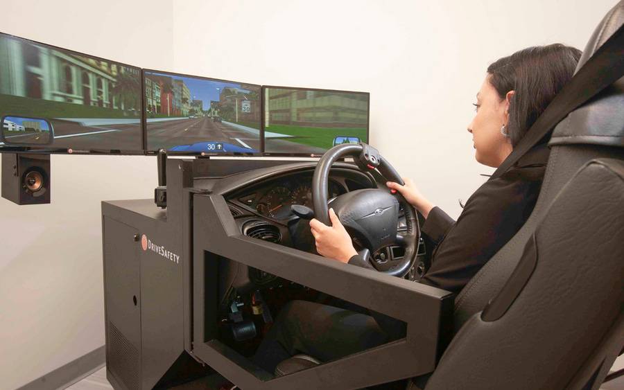 A woman sits in driving simulator that is being used in a study to help patients safely get back to driving after a brain injury.