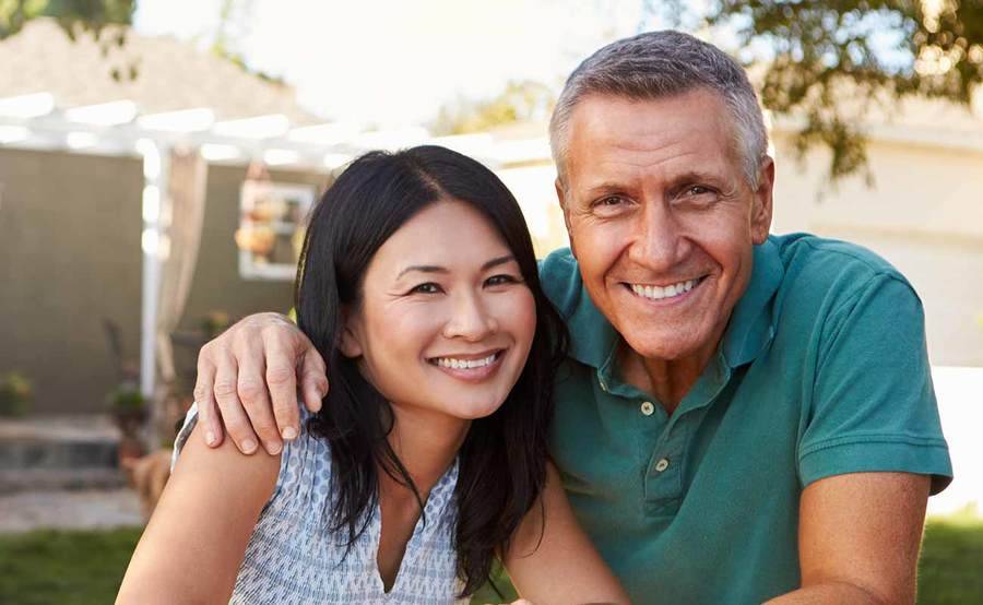 A smiling middle-aged Caucasian man and Asian woman represent the full life that can be led after treatment for sarcoma or bone cancer.