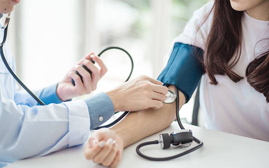 A doctor checks a woman's blood pressure as it relates to a Scripps MD who addresses key issues about women's heart health.