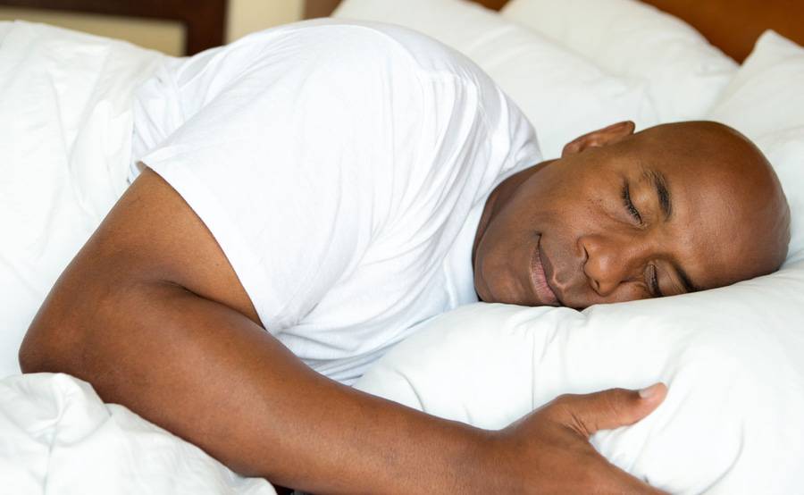 A man sleeping comfortably in bed represents how you can achieve a good night's rest with treatment from Scripps sleep medicine experts.