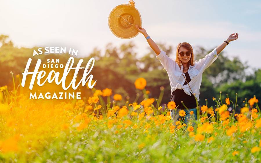 A young woman rejoices in a field of yellow flowers. SD Health Magazine