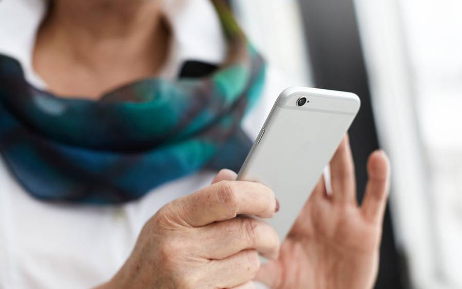 A middle age woman using her phone, represents the many Scripps patients that stay connected by following our social channels. 