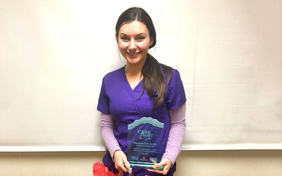 Scripps Green nurse, Stephanie Scirocco, smiles as she holds her CARE award that recognizes her outstanding service.