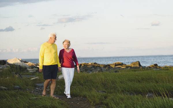 Joint replacement information class image of couple walking near ocean