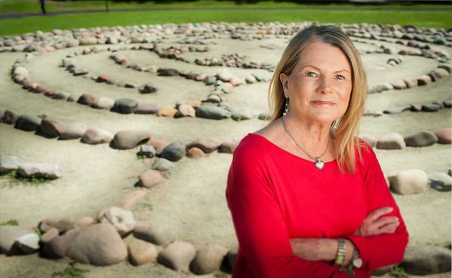 Portrait of heart patient and advocate Susan Iliff with meditation labyrinth in the background.