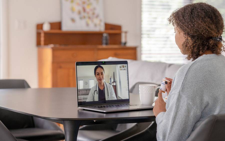 A patient discusses health issues during a video visit with her primary care physician.