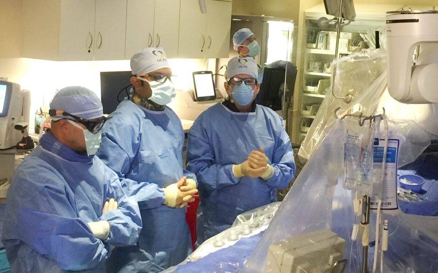 A team of doctors in an operating room as they prepare to begin a heart procedure that will be done through the wrist.