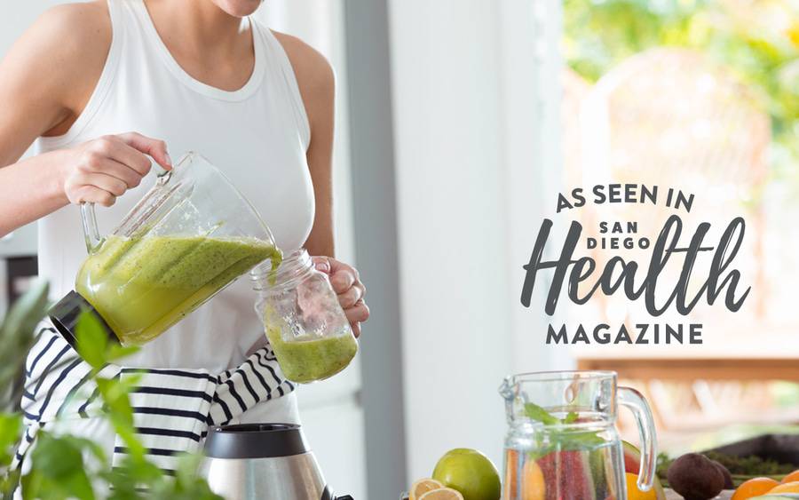 A woman pours a green smoothie from a blender into a mason jar, representing unhealthy eating habits.