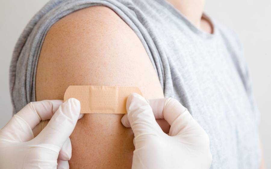 A band aid is placed over the arm where a patient received vaccination injections for flu, COVID and RSV.