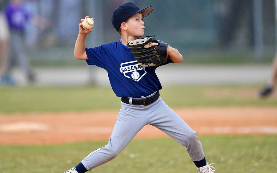 A young boy sets up to throw a pitch in a youth baseball game.