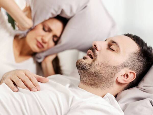 A man with sleep apnea snoring at night.