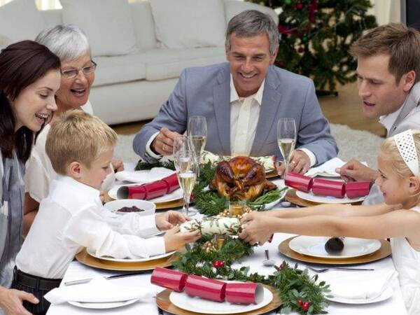 A family with small children gather around the table for a healthy holiday meal