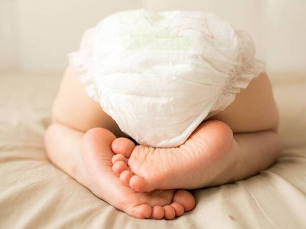 Baby bottom with diapers shown to illustrate article on causes and treatment for diaper rash.