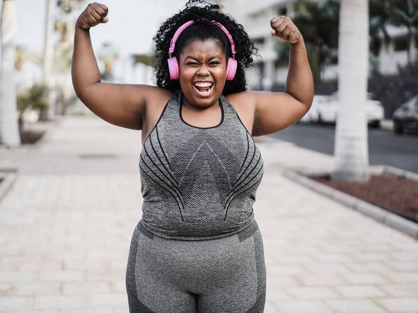 A young Black woman celebrates her recovery after gastric sleeve weight-loss surgery.